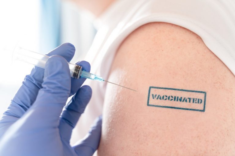 patient-hand-with-blue-stamp-vaccinated-doctors-syringe-with-vaccine-for-covid-19-coronavirus-flu_t20_0Xwp0v-768x512